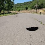 Găuri sub șoseaua care duce la Rătești. Localnicii se tem să nu se repete alunecările de teren din 2014